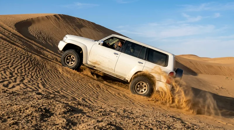 4x4 vehicle navigating steep dune in Al Wathba desert afternoon